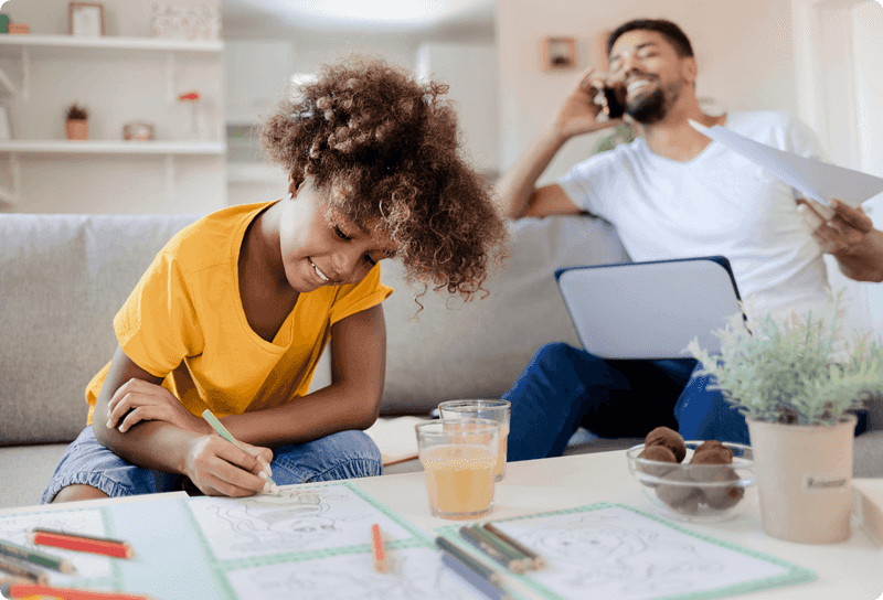 child using colouring pencils whilst parent is on the phone